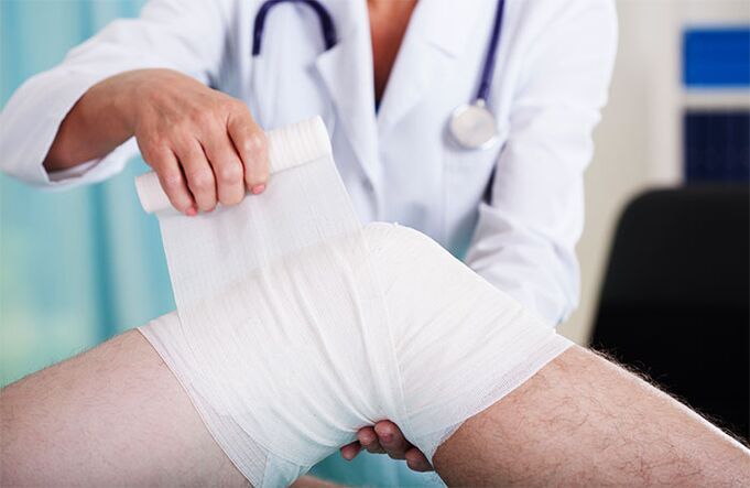 doctor who bandages the knee joint with osteoarthritis